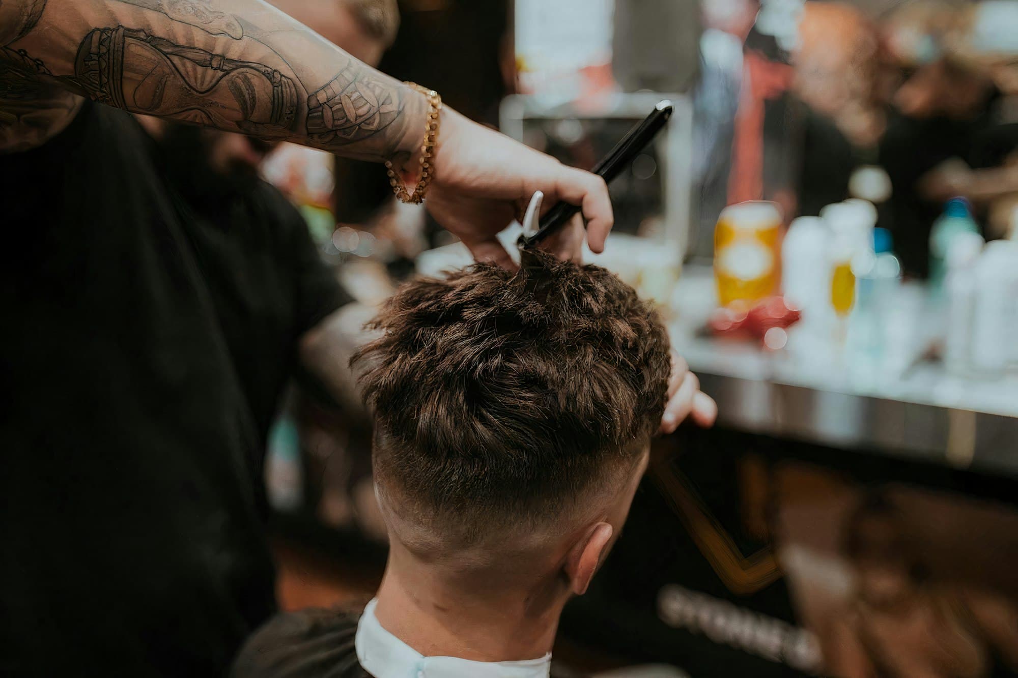 A barber finishing a precise cut in a warm barbershop