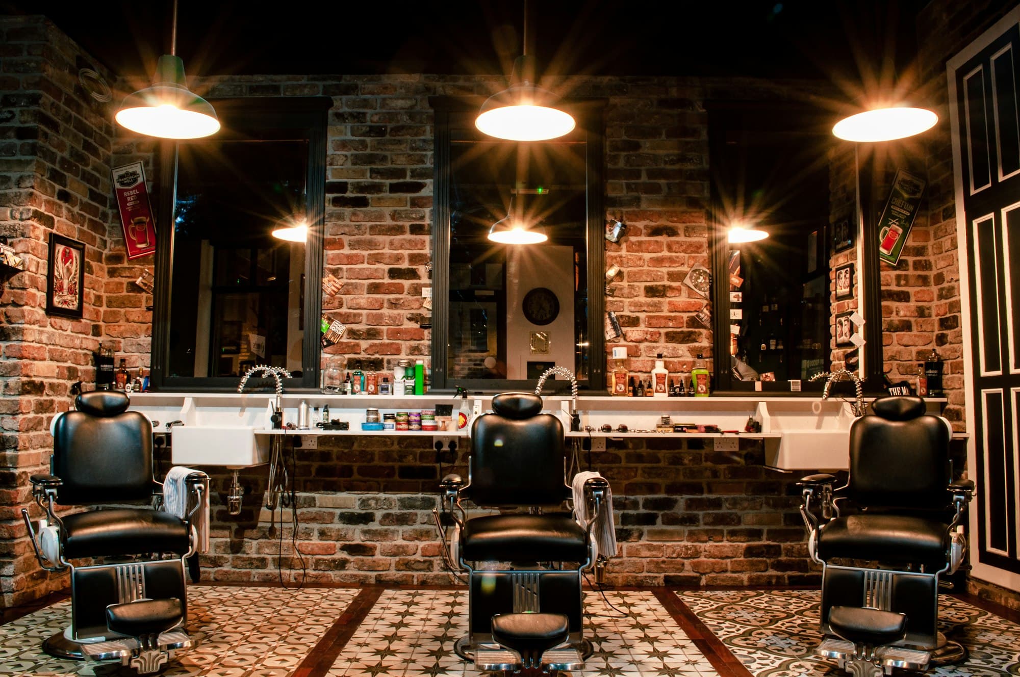 The interior of Devon's Barbershop — vintage chairs under warm light against exposed brick
