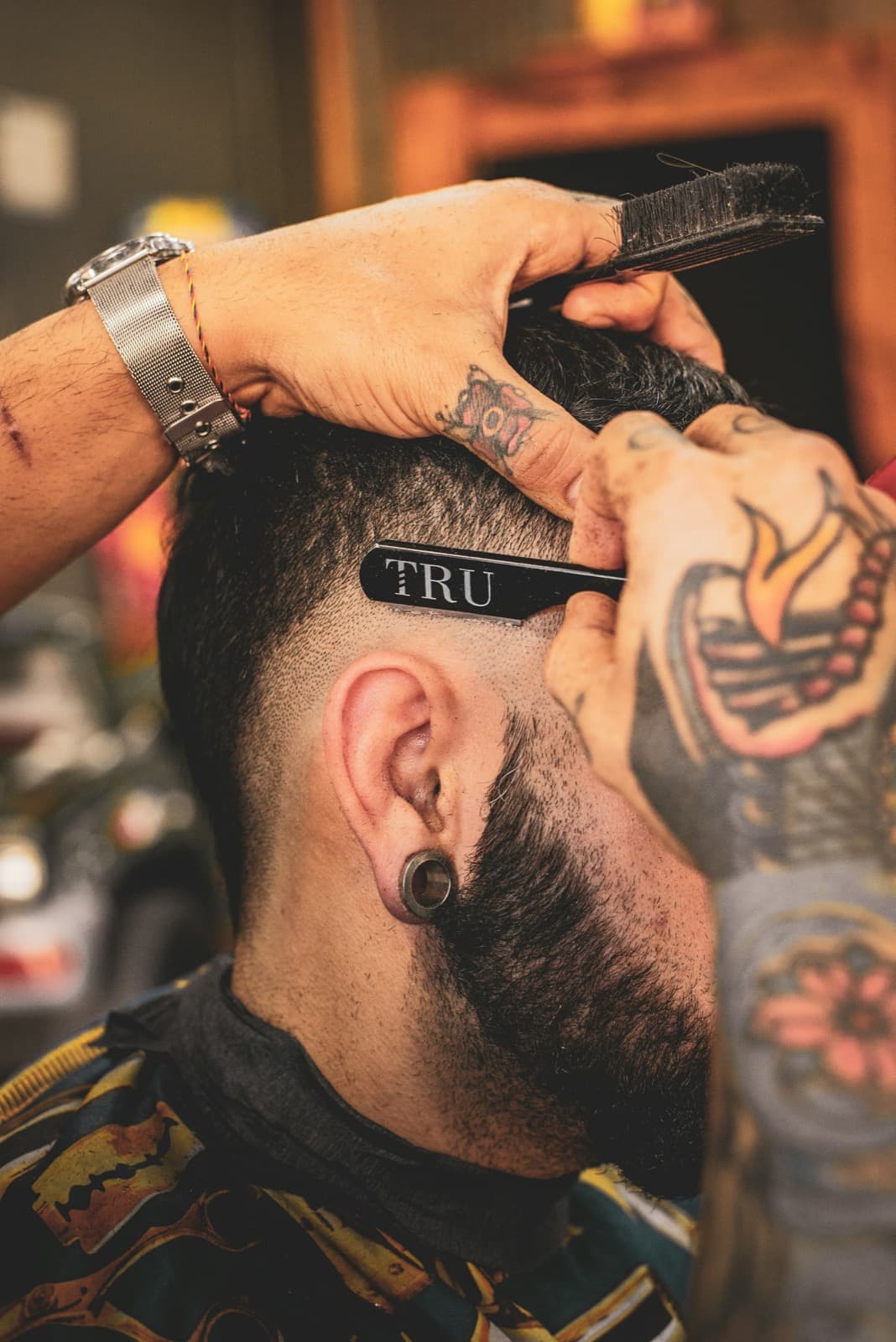 Close-up of a barber detailing a clean fade with a straight razor